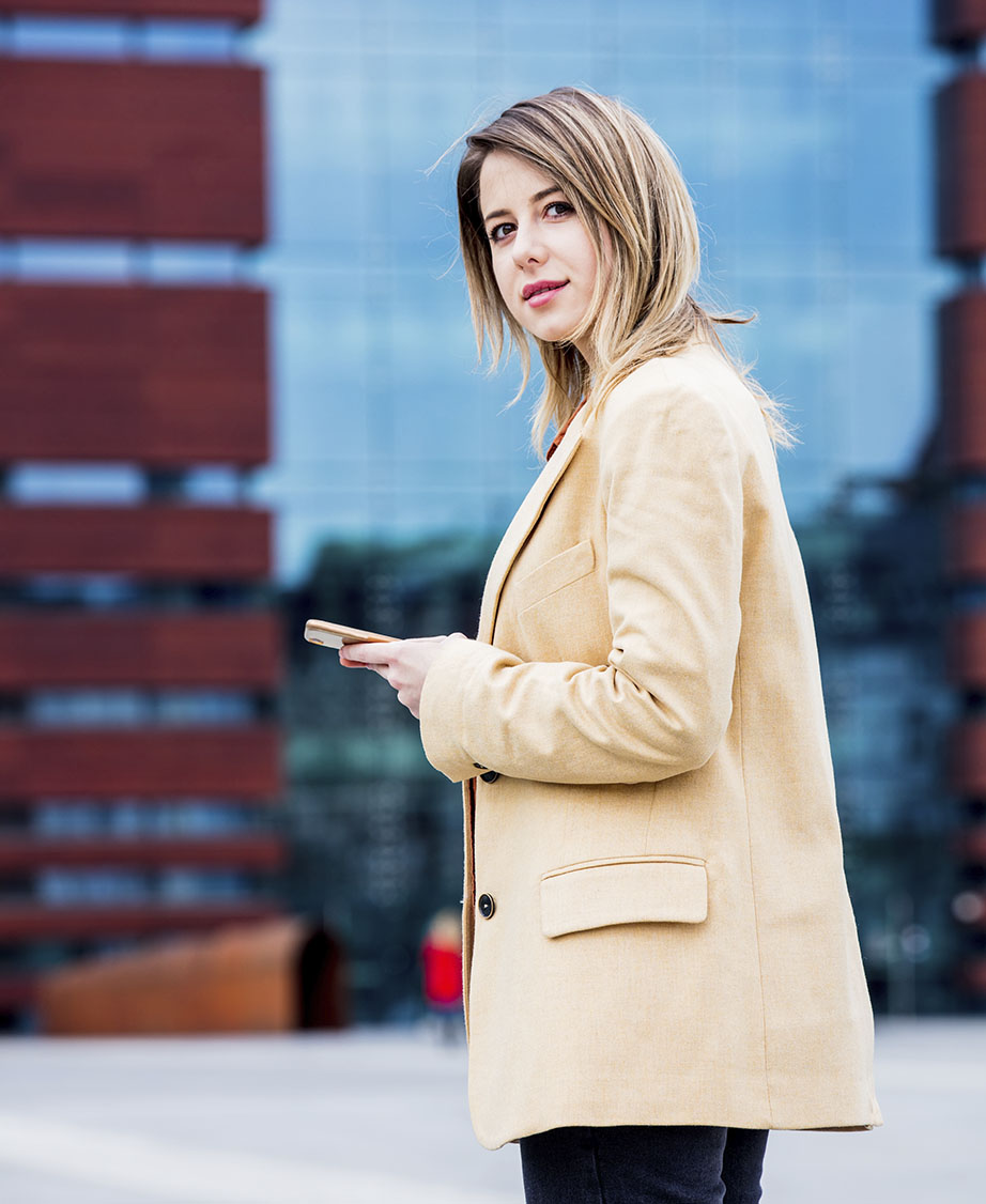 businesswoman-typing-message-by-phone-on-the-city-2022-01-12-05-09-31-utc.jpg